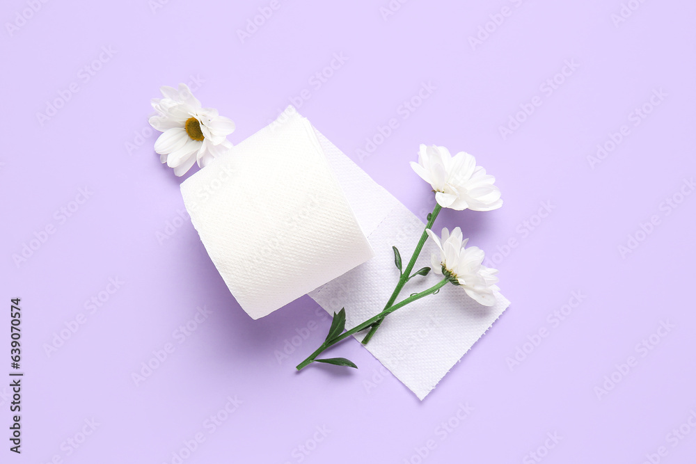 Roll of toilet paper with beautiful chamomile flowers on lilac background