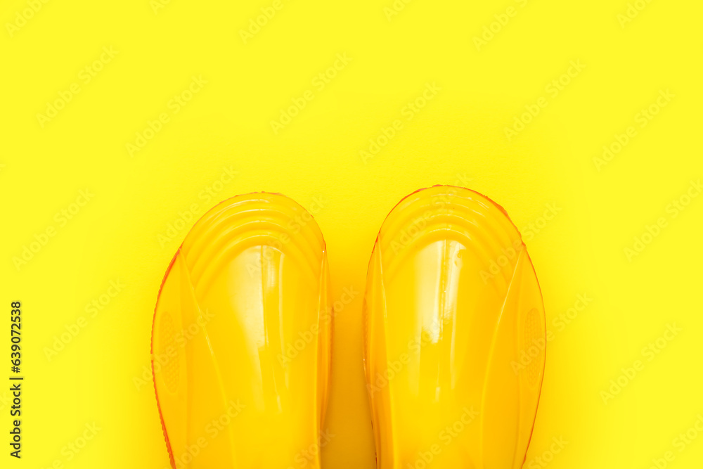 Yellow gumboots on color background