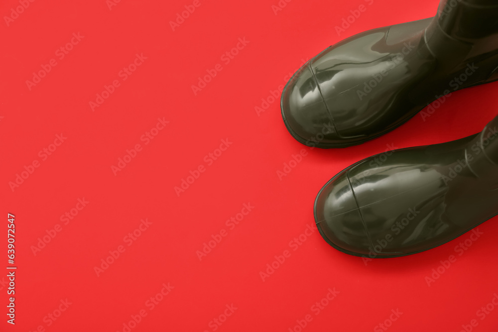 Green gumboots on red background