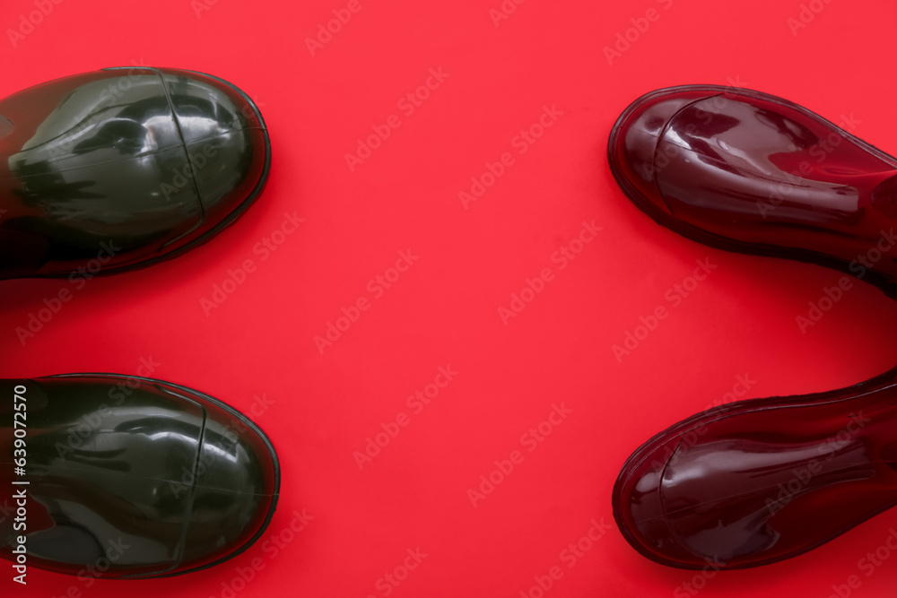 Different gumboots on red background