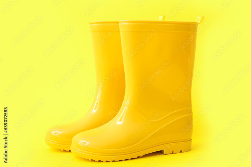 Yellow gumboots on color background