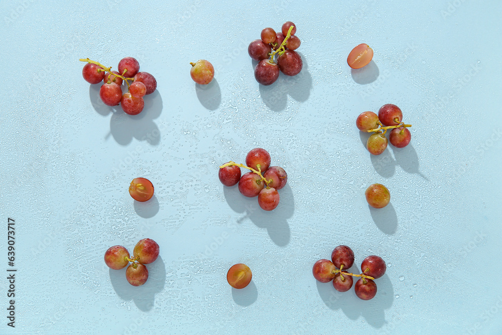 Tasty ripe grapes on blue background