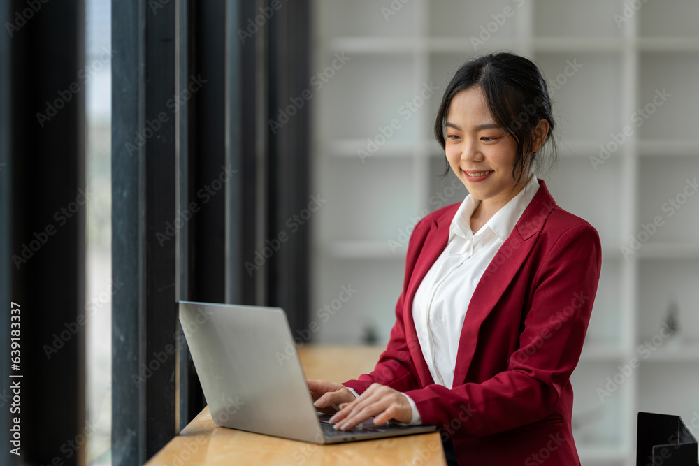 Attractive Asian businesswoman excited with laptop computer smartphone Finance, accounting, marketin