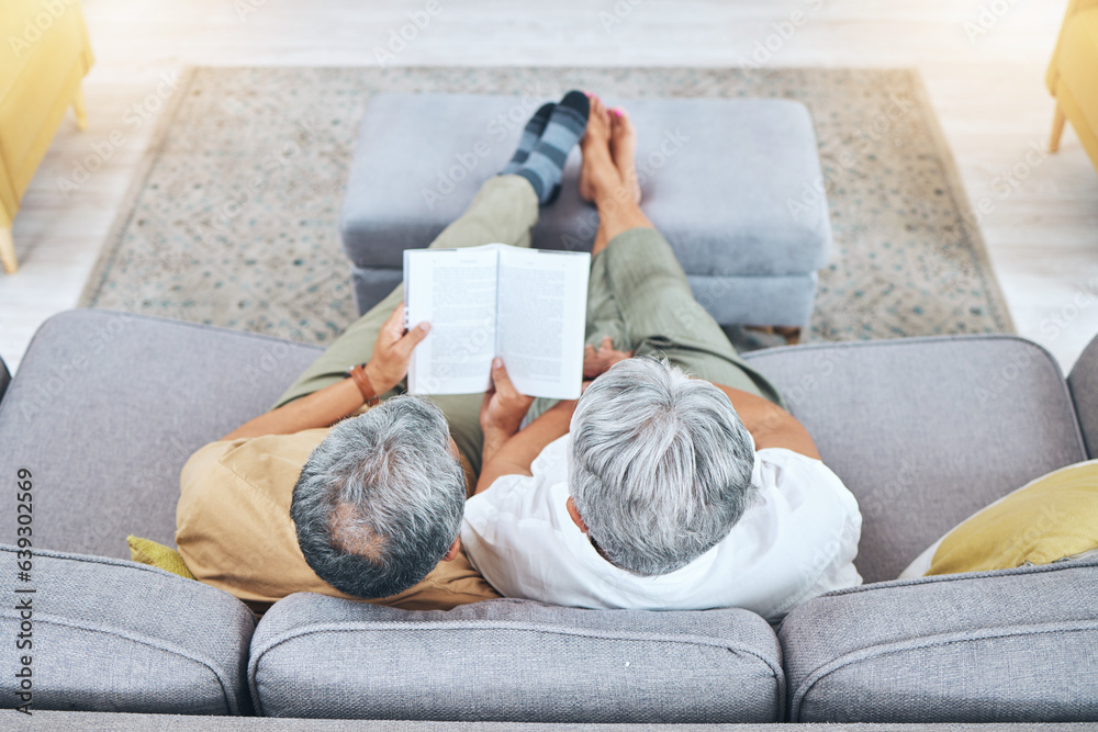 Relax, retirement and a senior couple reading a book on a sofa in the living room of their home from