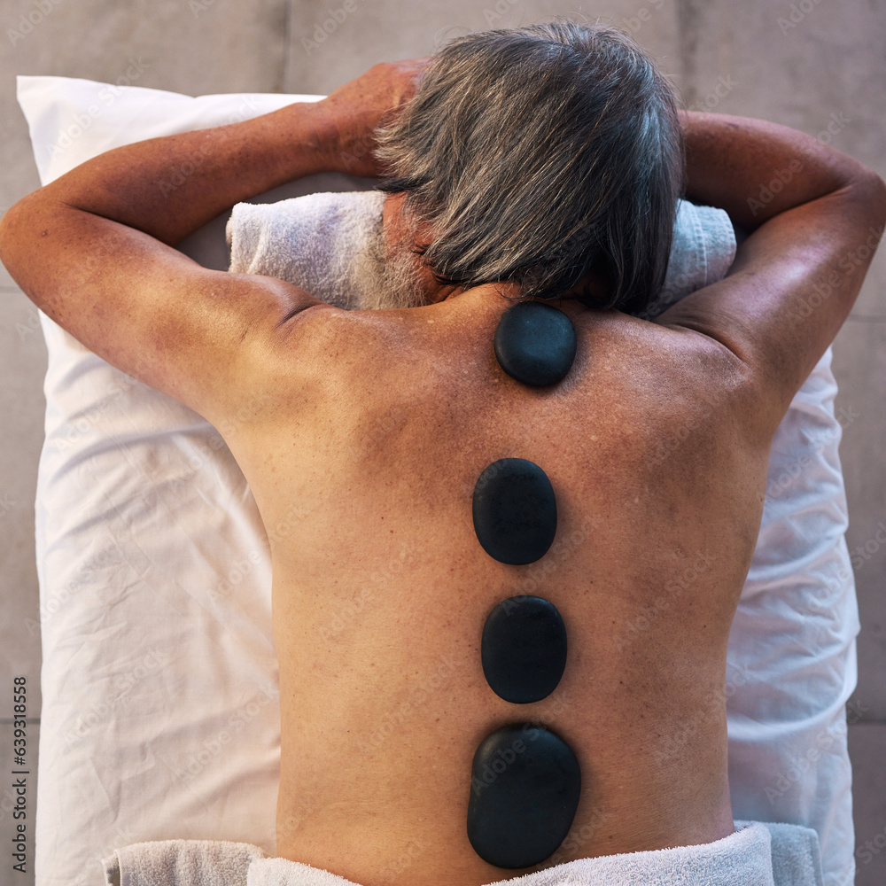 Hot stone massage and back of man in spa for wellness, holistic treatment and hospitality. Peace, co