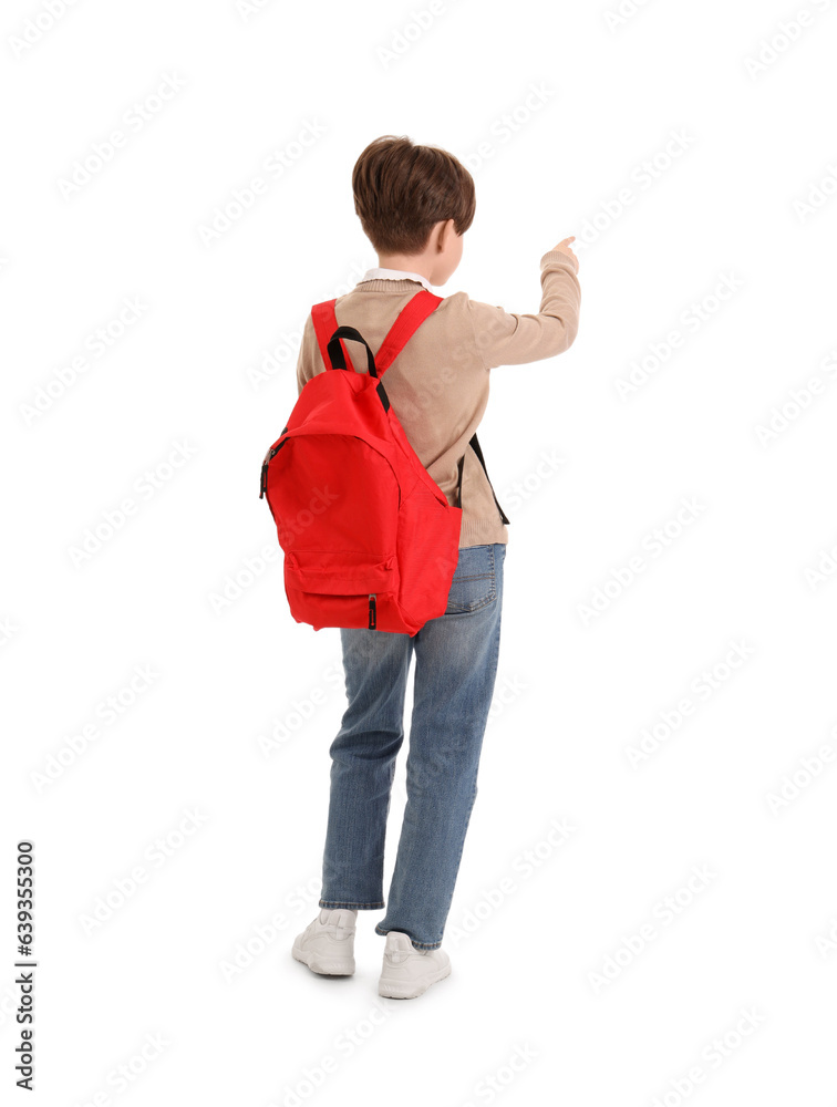 Little boy with schoolbag pointing at something on white background