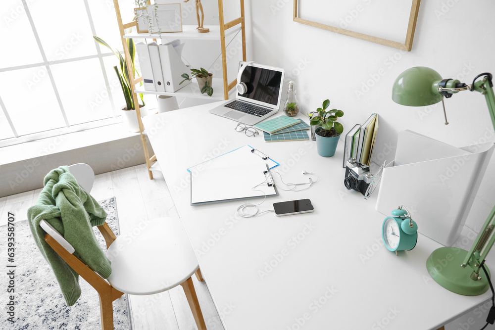 Modern workplace with laptop and stationery in office