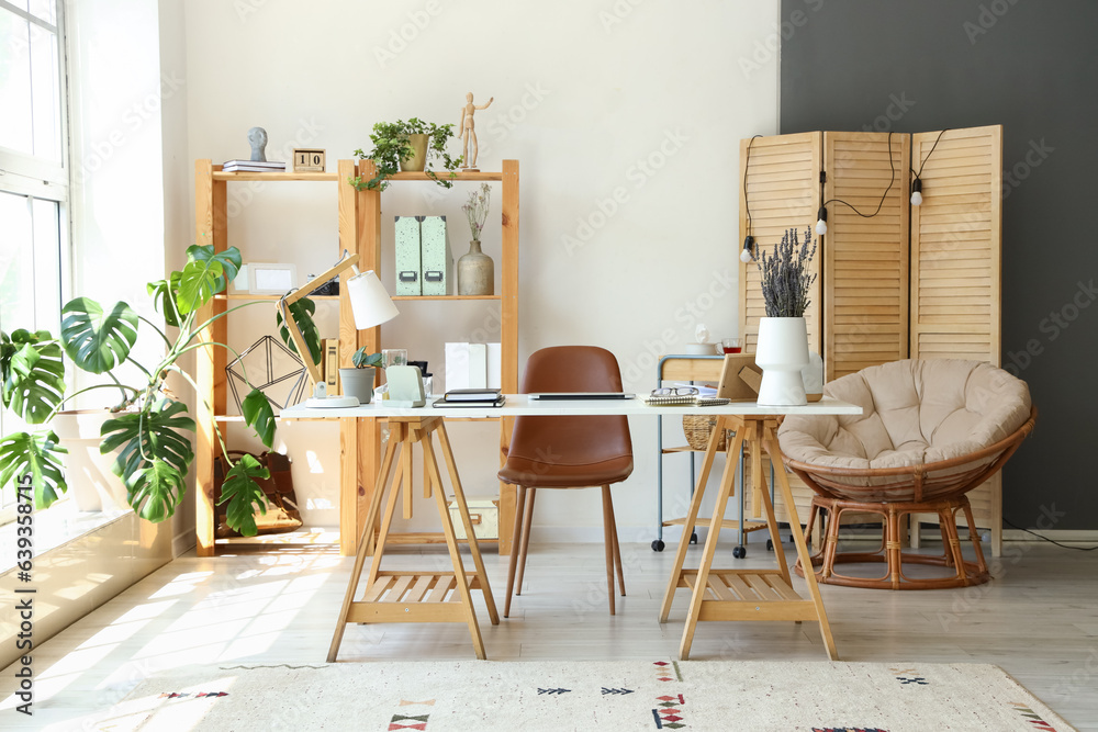 Modern workplace with laptop and lavender flowers in interior of office