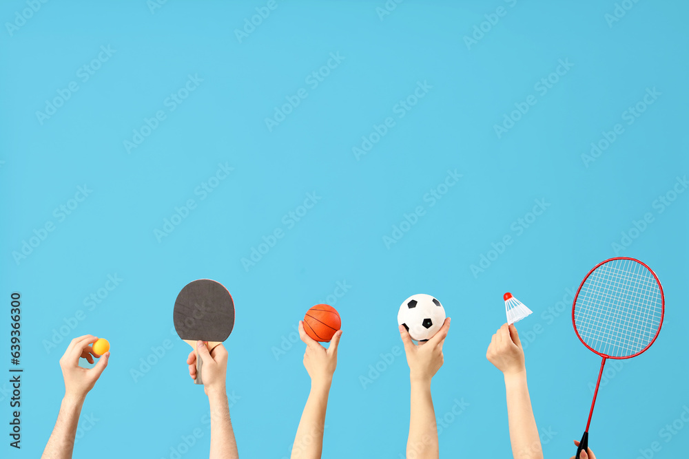 Female hands different sports equipment on blue background