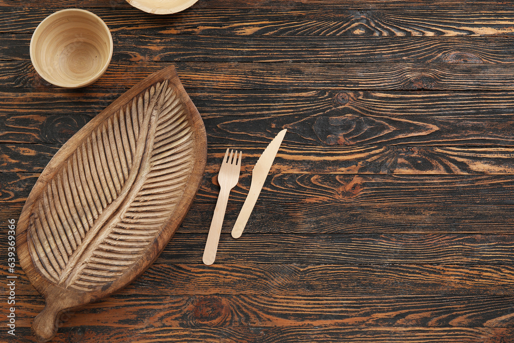 Board bowl and cutlery on wooden background