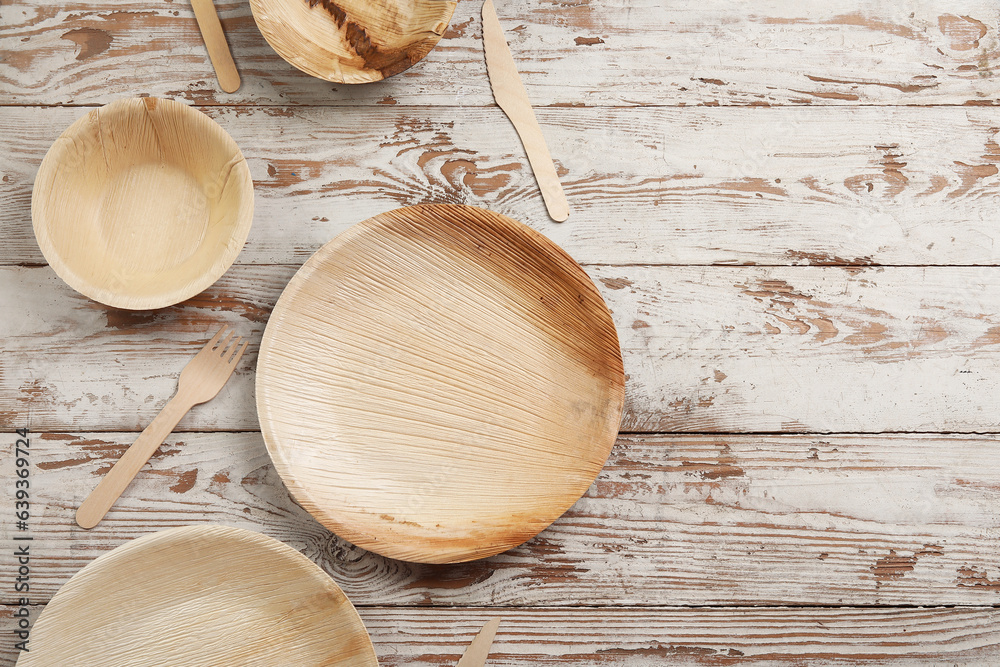 Different tableware on light wooden background