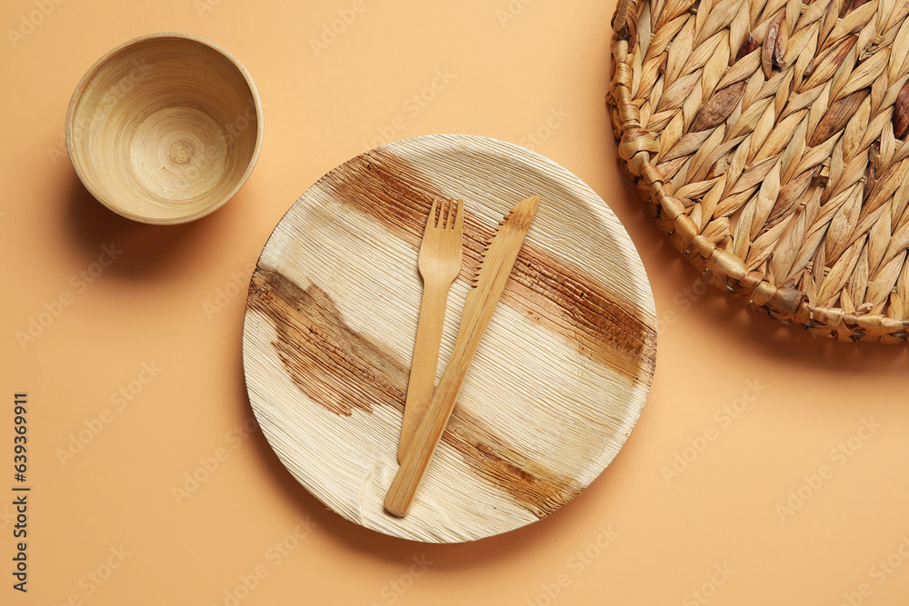 Different wooden tableware on beige background