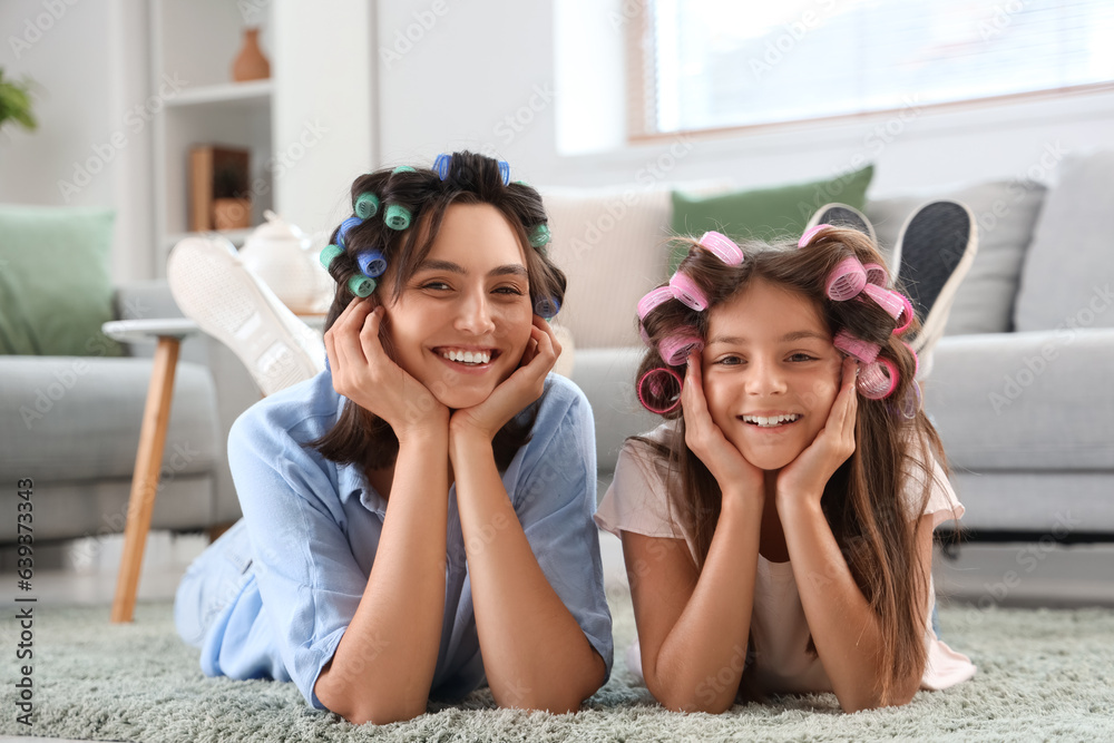 Little girl with her mother curling hair at home