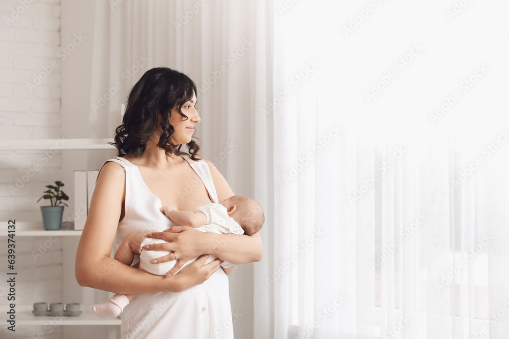 Young woman breastfeeding her baby at home