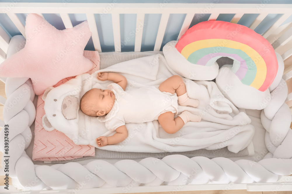 Cute baby lying in crib, top view