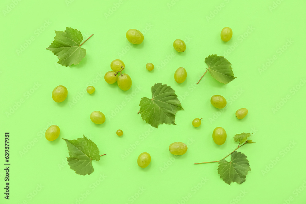 Sweet green grapes with leaves on color background