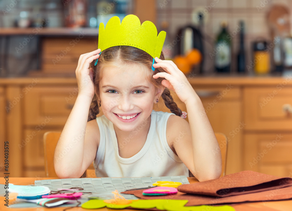 smiling little girl is engaged in needlework at home