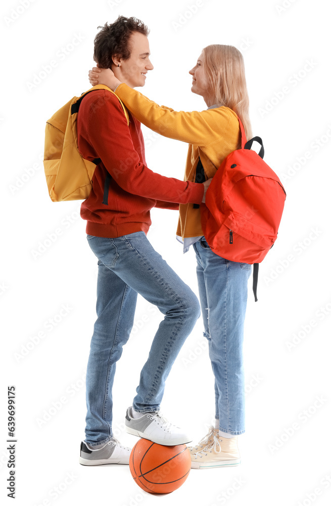 Teenage couple with ball hugging on white background