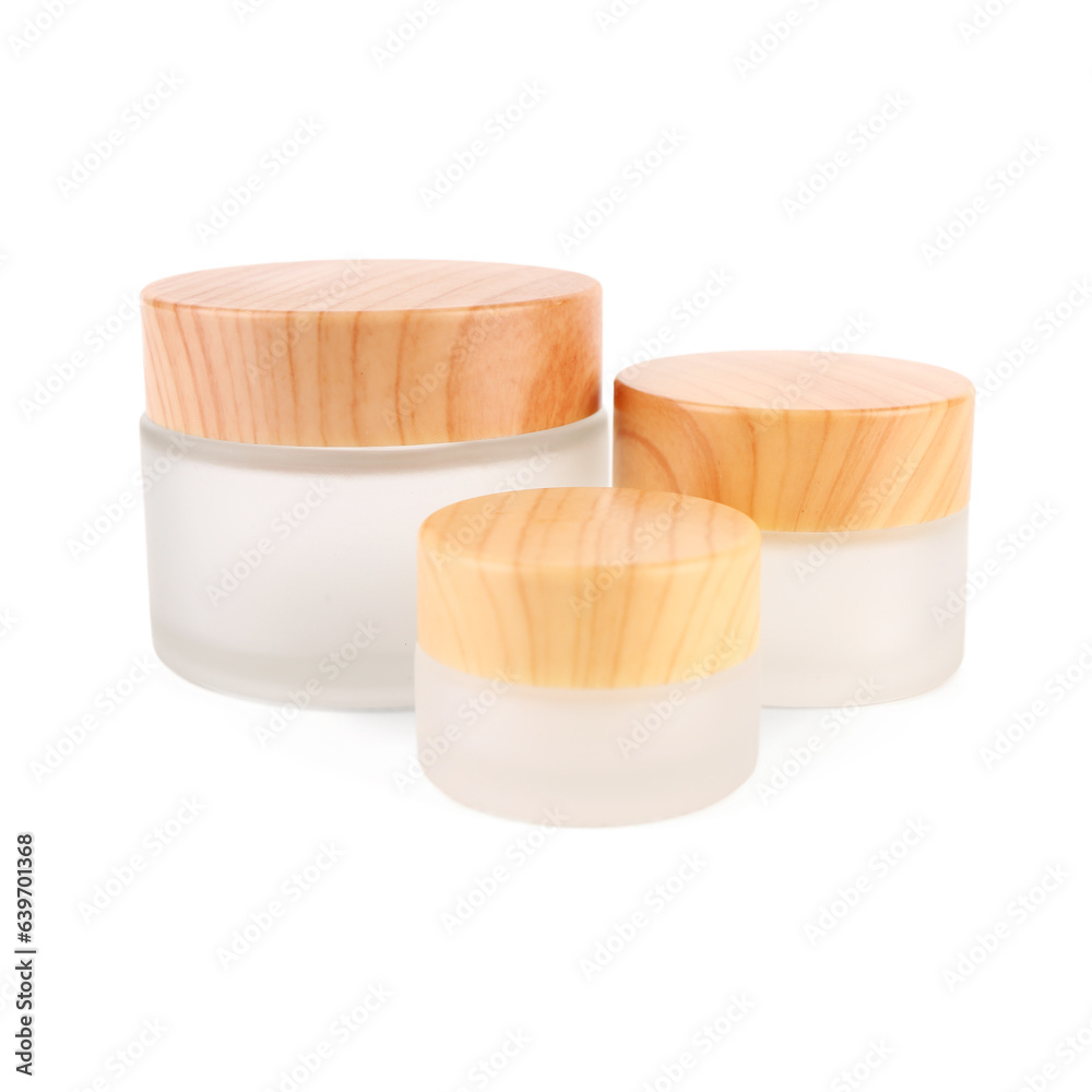 Cosmetic jars with wooden lids on white background