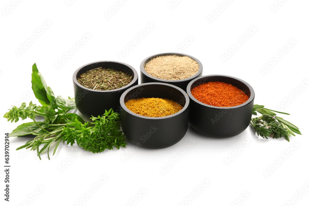 Bowls with spices and fresh herbs isolated on white background