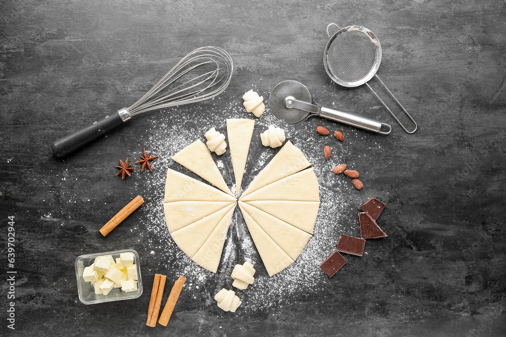 Composition with raw dough, ingredients and utensils for preparing bakery on dark background