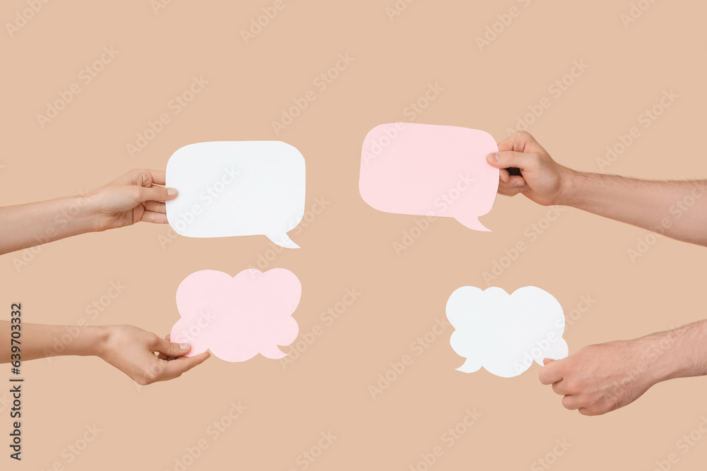 Different hands with speech bubbles on beige background