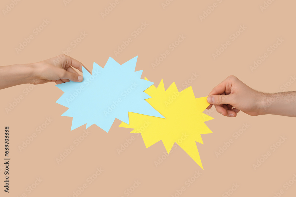 Different hands with speech bubbles on beige background