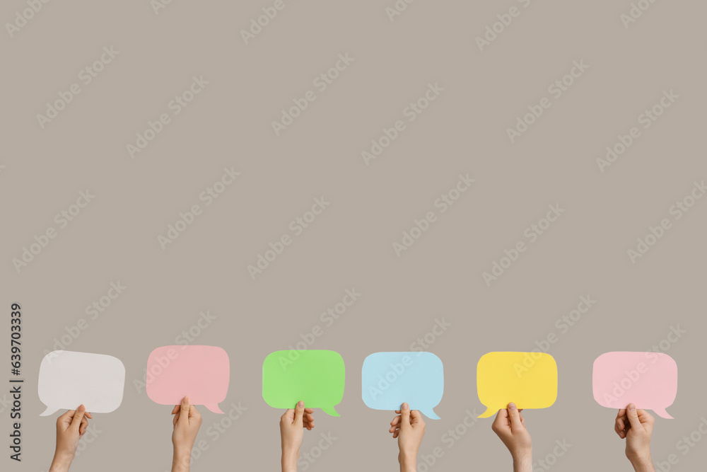 Different hands with speech bubbles on grey background