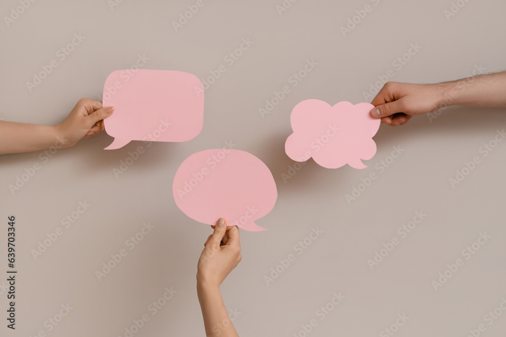 Different hands with speech bubbles on grey background