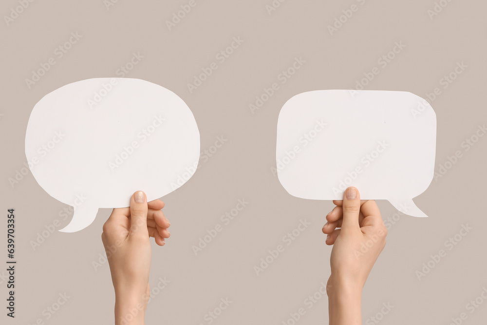 Female hands with speech bubbles on grey background