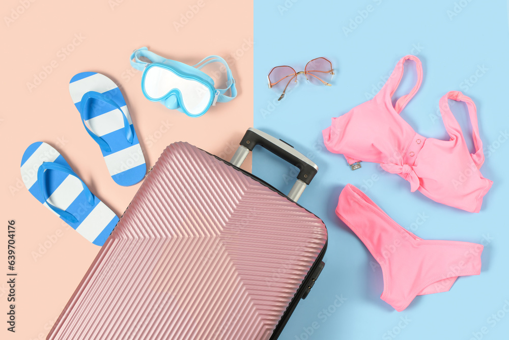 Composition with suitcase and beach accessories on color background