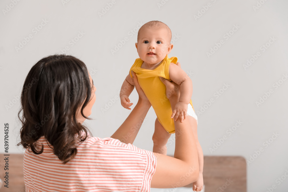 Young woman with her baby in bedroom