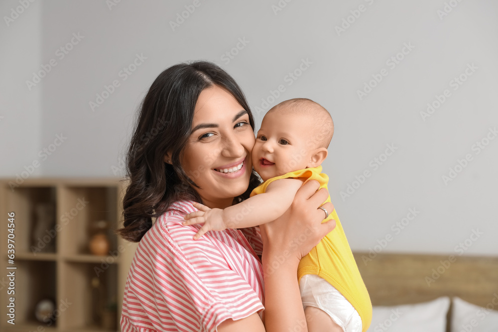 Young woman with her baby in bedroom