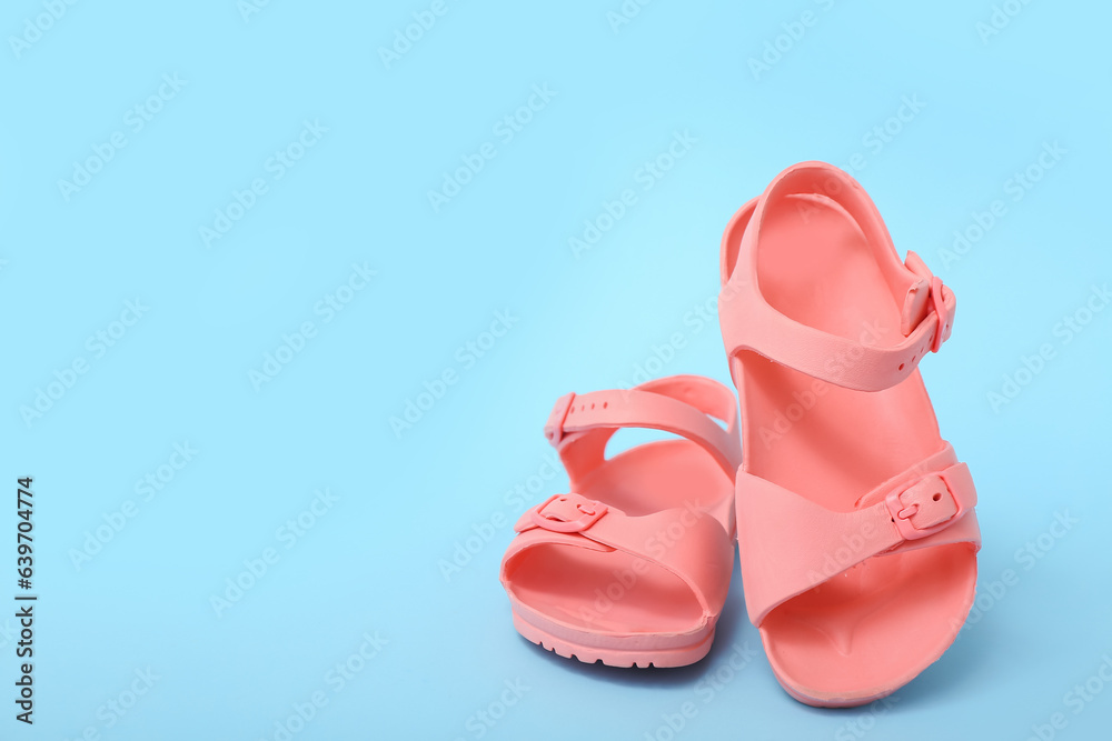 Pair of stylish childs sandals on color background