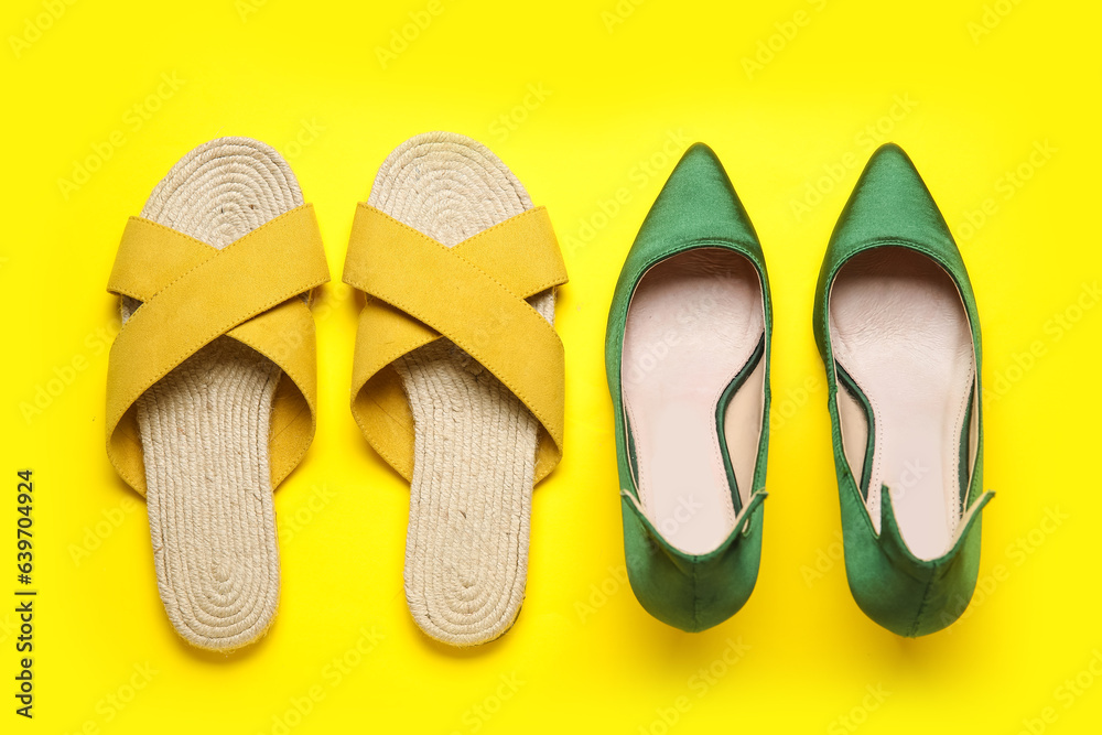 Different stylish shoes on yellow background