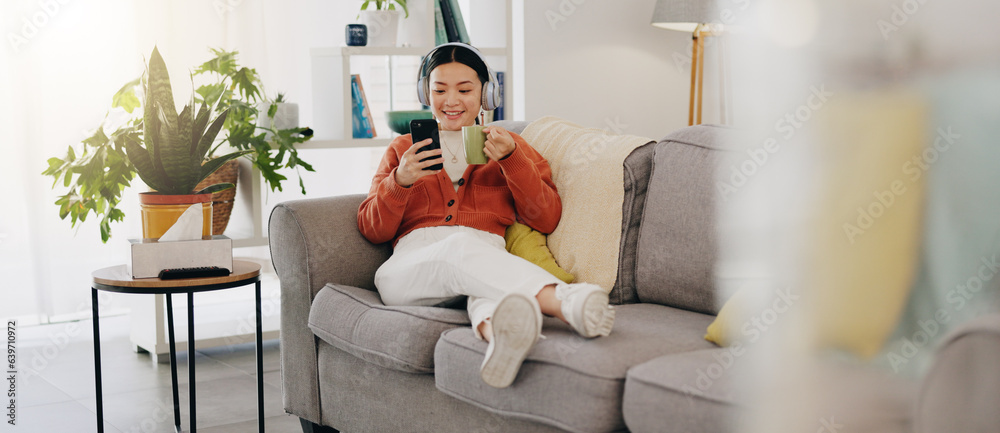 Asian woman, phone or music headphones on relax sofa in house or Japanese home living room. Smile,en