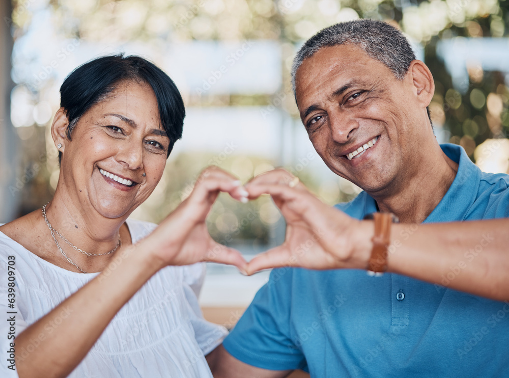 Portrait, hands and heart with a senior couple in the living room of their home together to relax. F