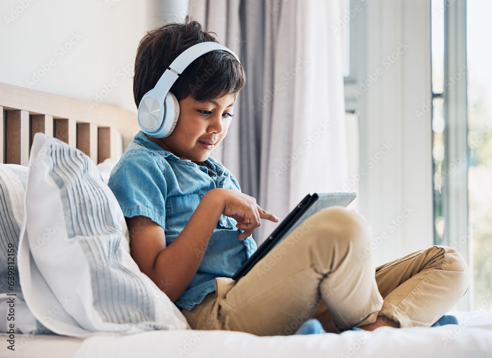 Boy, kid and headphones with tablet on bed for online games, watching movies or play educational app