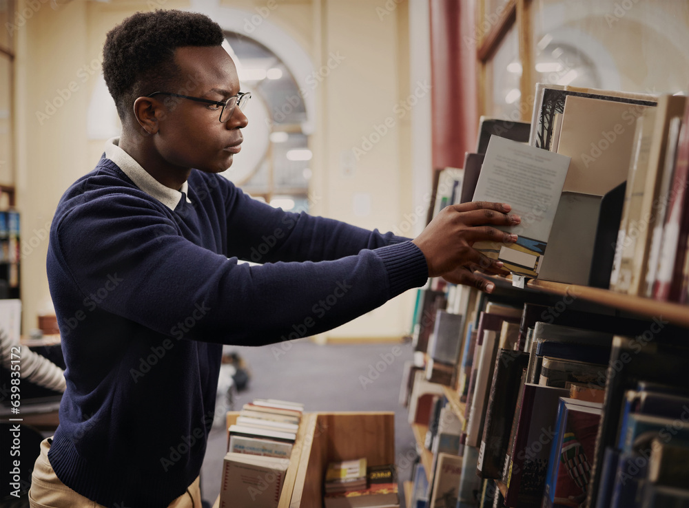 University, research and man in a library reading and learning on campus for knowledge and education