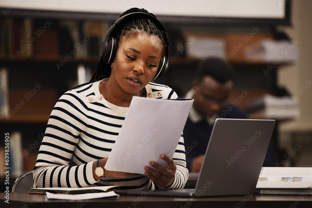 Woman, documents and headphones in library for research, studying and computer research or planning 