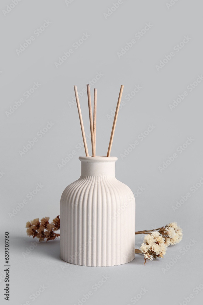 Floral reed diffuser and flowers on grey background