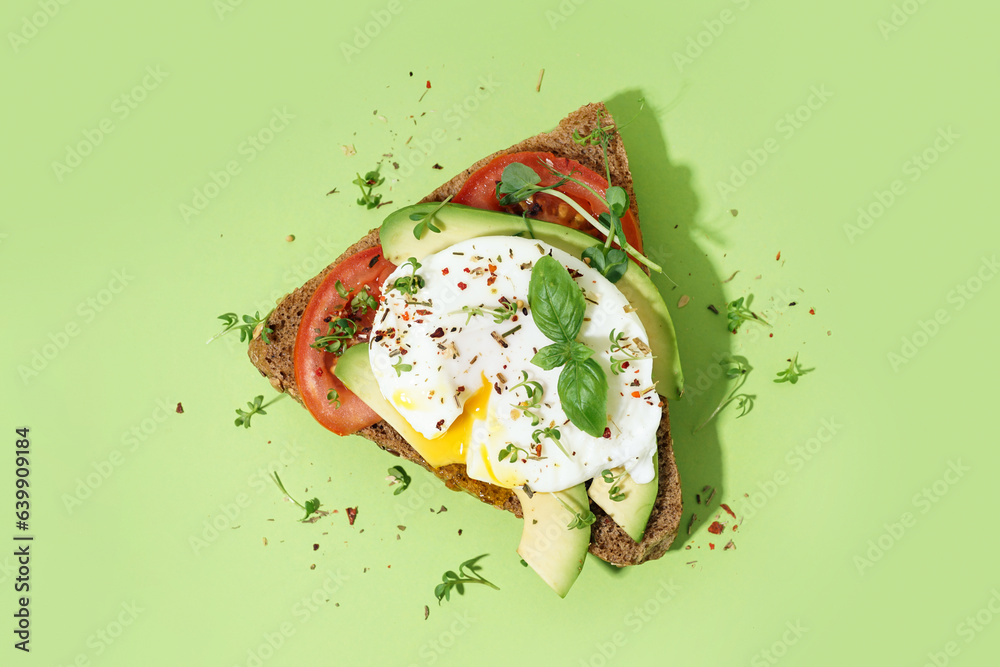 Tasty sandwich with egg on green background