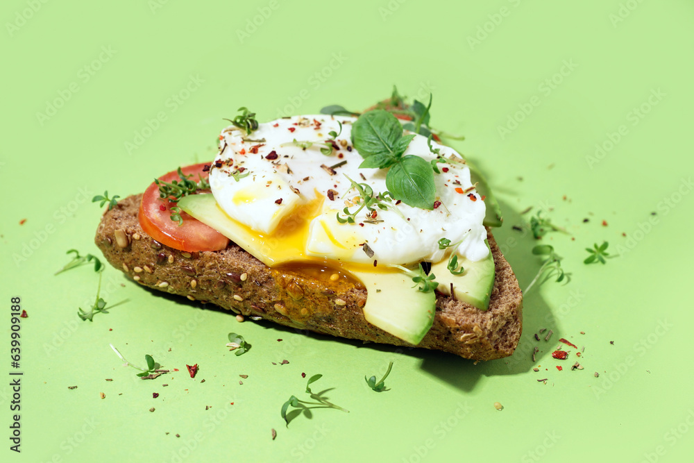 Tasty sandwich with egg on green background