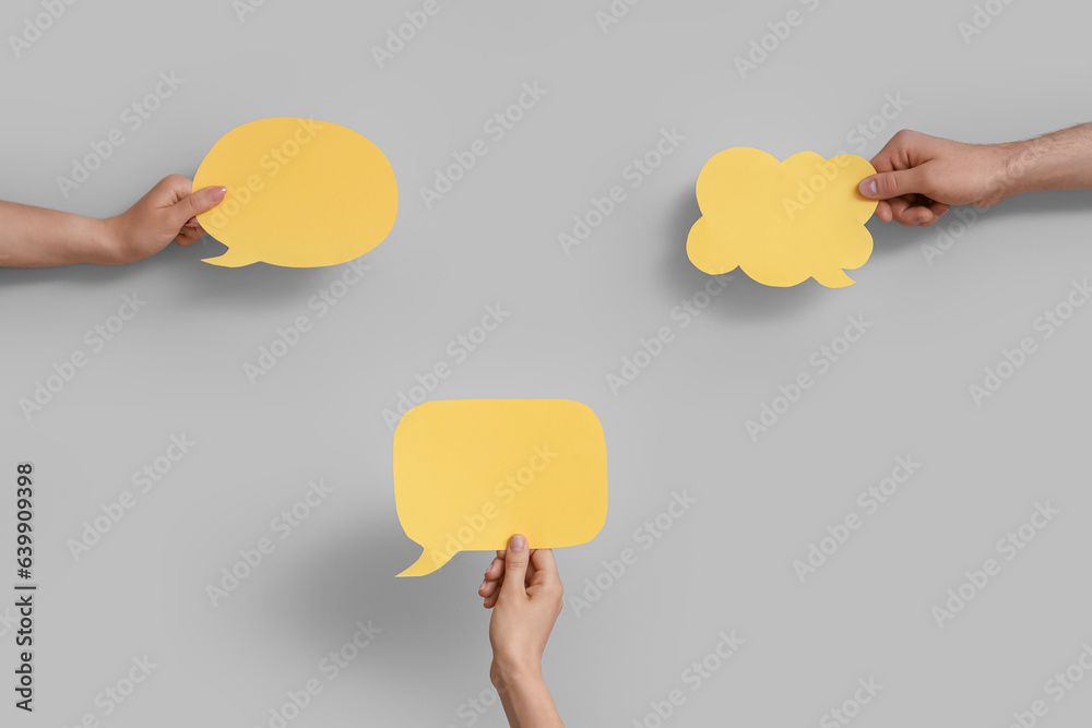 Different hands with speech bubbles on grey background