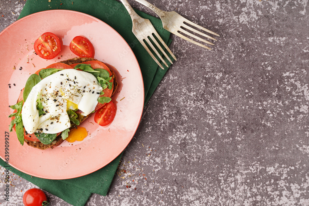 Plate of tasty sandwich with egg on grey background