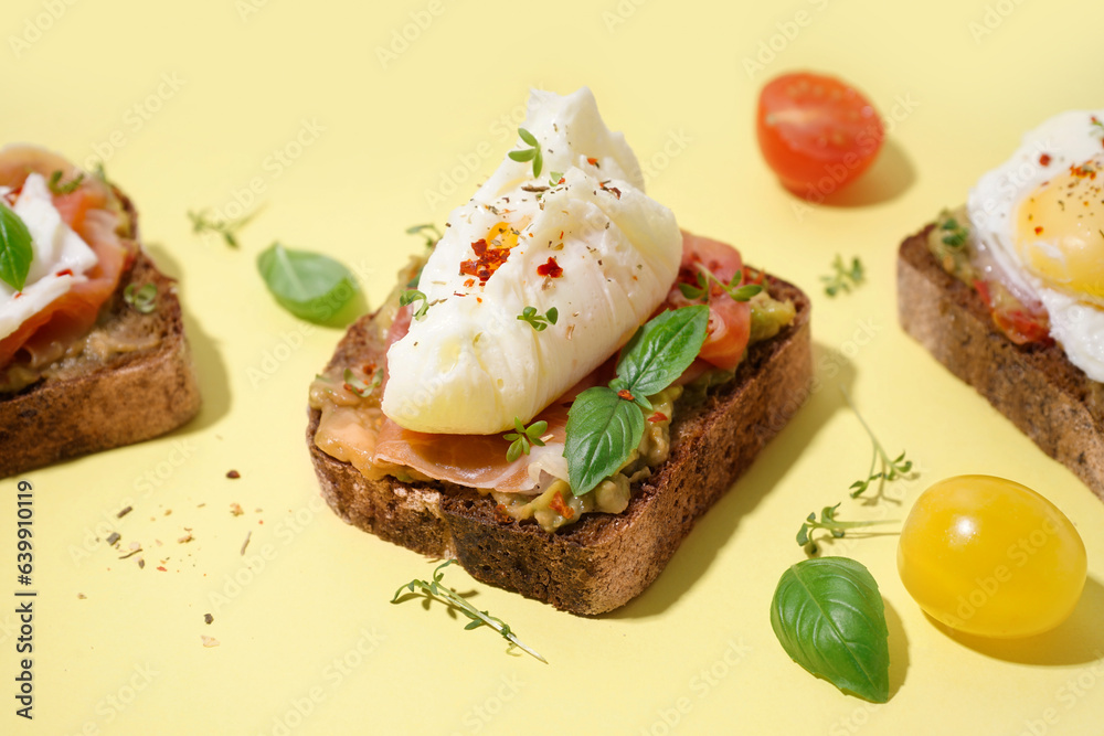 Tasty sandwiches with egg on yellow background