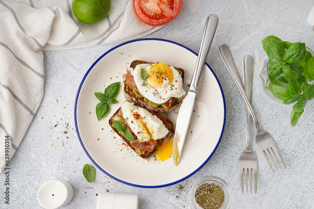 Plate of tasty sandwiches with egg on grey background