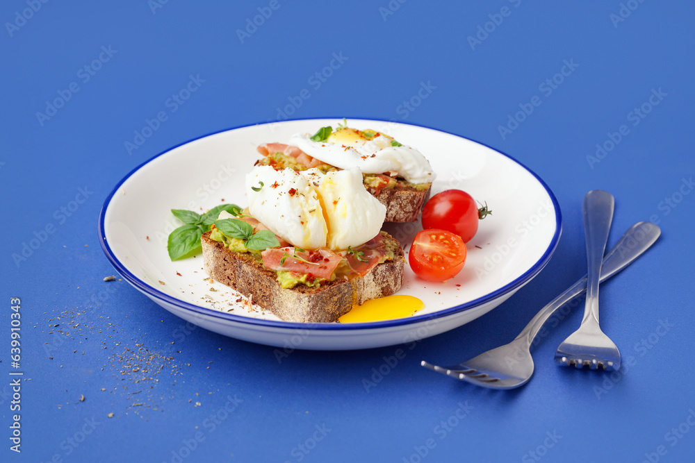 Plate of tasty sandwiches with egg on blue background