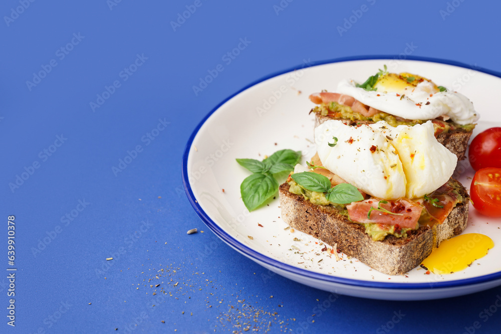 Plate of tasty sandwiches with egg on blue background