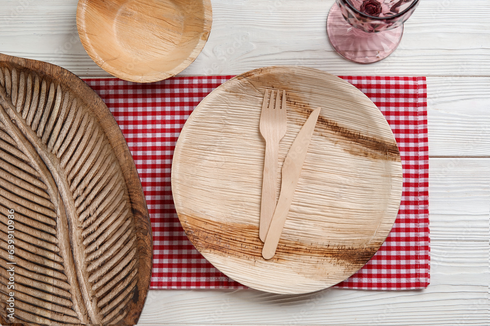 Plate, bowl, board and glass on light wooden background